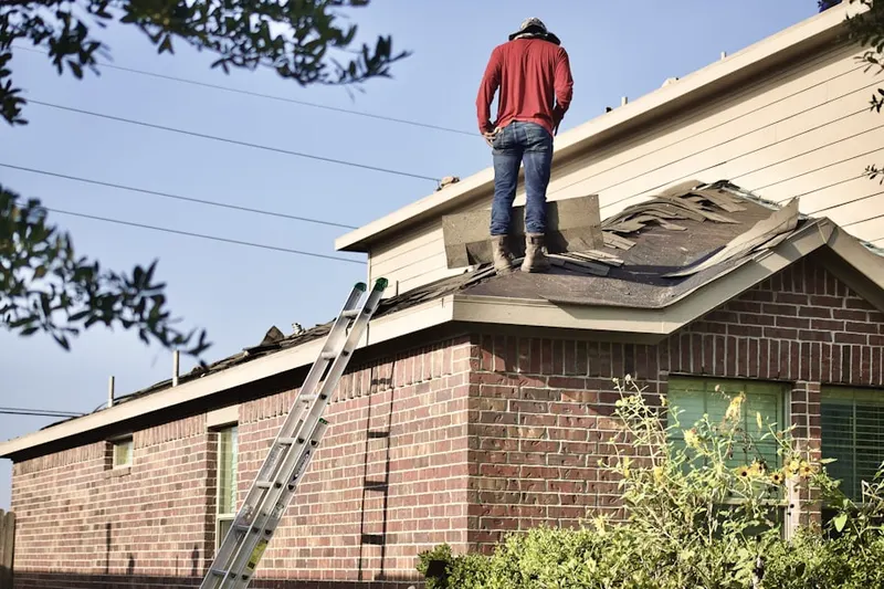 Professional roofer working on a residential roof in Haleyville